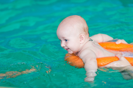 Mother with baby in swimming pool trainingの写真素材