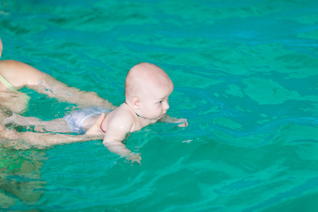 Mother with baby in swimming pool trainingの写真素材