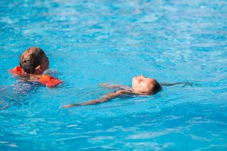 Cute little girl in swimming pool learning how to swimの写真素材