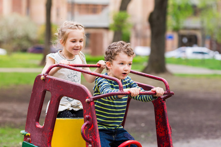 Excited happy kids driving a toy car outdoorの写真素材
