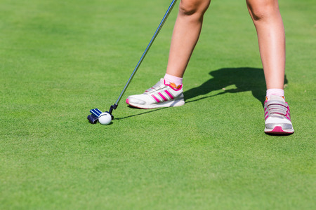 Low section of male golf player ready to hit the ballの写真素材