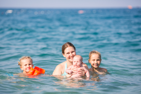 Happy mother with kids in the sea having funの写真素材