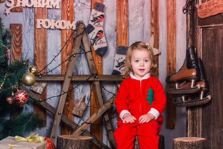 Happy cute little baby in Santa's costume near Xmas treeの写真素材