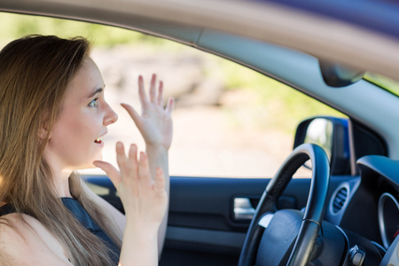 Scared woman behind the wheel brakes. The woman behind the wheel concept. Dangerous driving conceptの写真素材