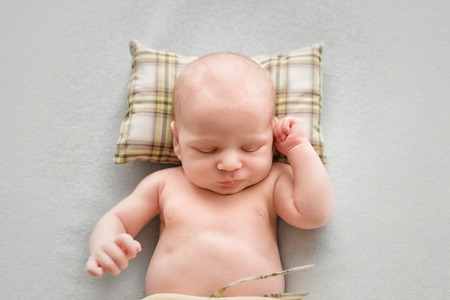 Sleeping newborn baby boy on a pillowの写真素材