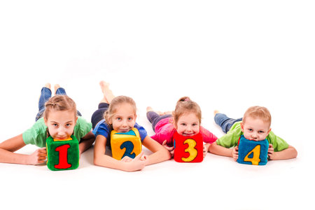 Happy kids holding blocks with numbers over white background. Teamwork concept.