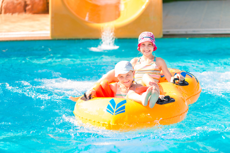 Cute happy girls in amusment aquapark. Summertime, vacation concept.の写真素材