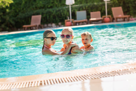 Happy kids having fun at the pool at the resort