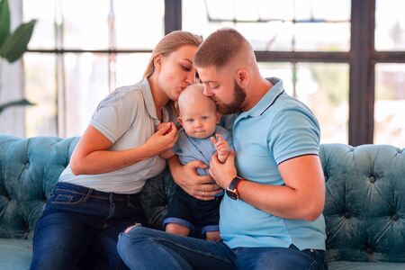 Young happy family with the baby at home indoorsの写真素材