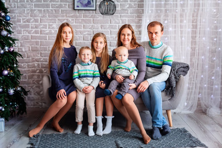 Happy family having fun together near Christmas tree at home