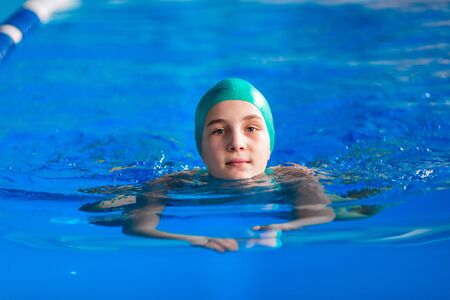 Cute little girl training in a swimming pool. Swimming sport for kids conceptの写真素材