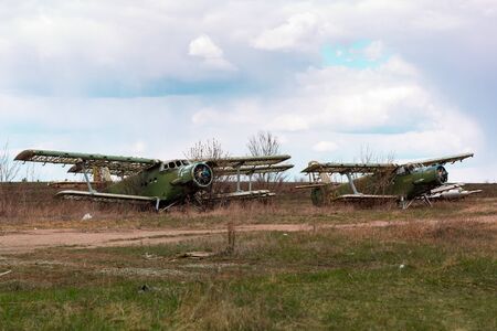 Old destroyed Soviet abandoned military airplanes in the field in Ukraine. Former soviet aviation wreckage after second world warの写真素材