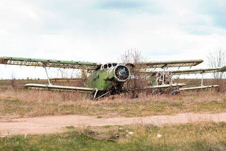 Old destroyed Soviet abandoned military airplanes in the field in Ukraine. Former soviet aviation wreckage after second world warの写真素材