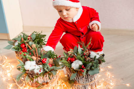 Cute small Santa Claus with Christmas flower decoration. Holiday and Christmas moodの写真素材