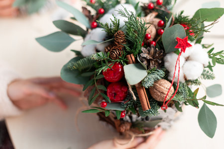 Creating Christmas floral arrangement with carnations, chrysanthemum santini flowers and fir. Floral...