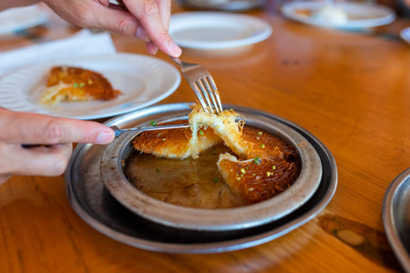 Turkish dessert kunefe, kunafa, kadayif with pistachio powder and cheese, served hot, very sweet....