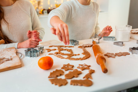 Christmas bakery. Friends making gingerbread, cutting cookies of gingerbread dough, view from above. Festive food, cooking process, family culinary, Christmas and New Year traditions conceptの写真素材