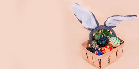 Easter basket with painted eggs banner. Easter holiday tradition. Easter Egg Hunt. Colorful easter eggs. Spring religious holidayの写真素材