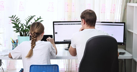 Father with his teen daughter trying to work from home during quarantine. Stay at home, work from home concept during virus pandemicの写真素材