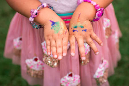 Shimmering sparkling glitter tattoo on a child's hand at a birthday party. Body artの写真素材
