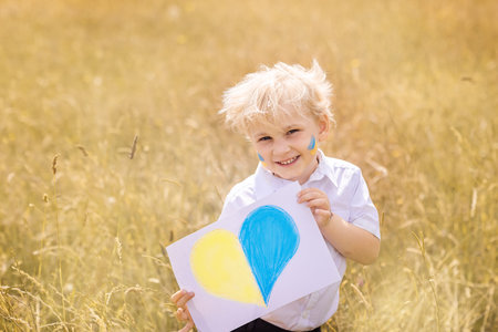 Stop War in Ukraine. Ukrainian boy with Ukrainina flag- yellow and blue stands against war.