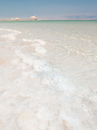 Landscape view on Dead Sea salt crystals formations, clear cyan green calm water at Ein Bokek beach, Israelの写真素材