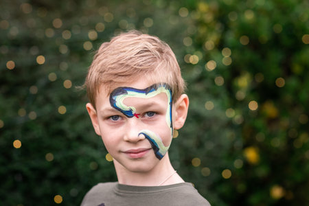 Cute little boy with face paint. Face painting, kid painting face at the birthday party or on...