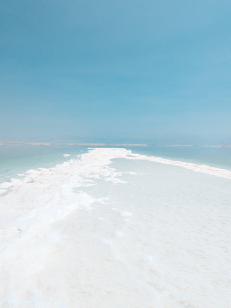 Landscape view on Dead Sea salt crystals formations, clear cyan green calm water at Ein Bokek beach, Israelの写真素材