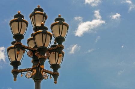 Street  lamp with ornament and  blue sky in background