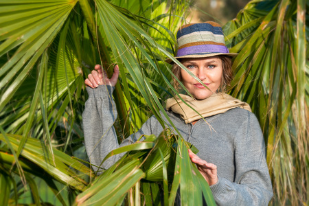Smiling woman with headscarf next to palmsの写真素材