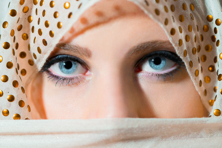 Close up portrait of beautiful  woman  with blue eyes covered by scarfの写真素材