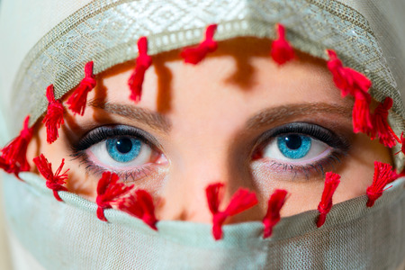 Close up portrait of beautiful  woman  with blue eyes covering faceの写真素材