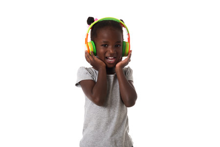 Music and technology concept.African lovely little girl   with headphone singing.Studio shot on white background の写真素材