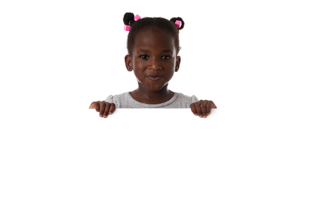 Portrait of little african girl in studio with white board.Isolated.Copyspaceの写真素材