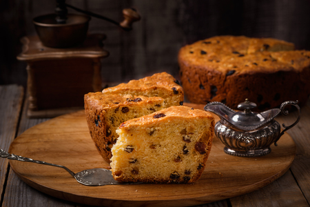 Slices of home made cake with raisins on wooden plate and coffee grinder,vintage styleの写真素材