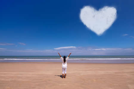people, fitness, sport and healthy lifestyle concept - young asian woman making yoga pose on tropical beach with laptopの写真素材