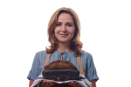 Portrait of woman in apron showing a sourdough homemade bread, isolated on white background.の写真素材