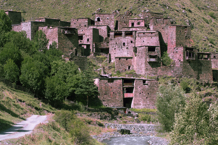 Ancient high-altitude city-fortress in Georgia. Stone houses stuck to the mountainside. Mountain river in the gorgeのeditorial素材