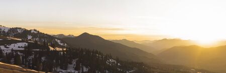 Mountain landscape panorama. Sunlight from the setting sun. Mountain slopes overgrown with forests.の写真素材