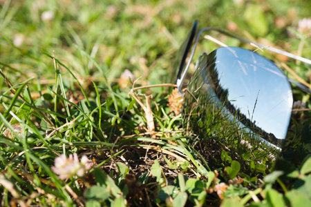 Sunglasses on the green grass. The glasses reflect a clear summer day with a beautiful landscape....