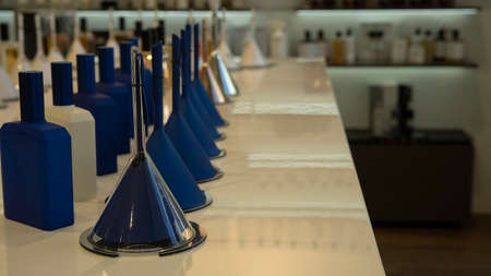 Perfume bottles and funnels with fragrance on the counter in a luxury store. cosmetic products exhibition saleの写真素材