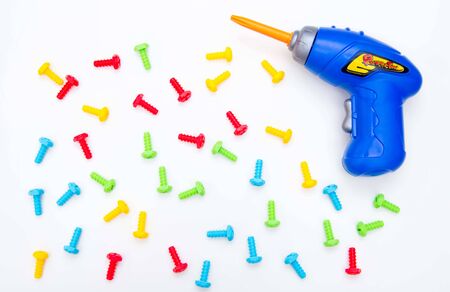 Toys background. Top view of toy tools. Screwdriver and colored bolts. Isolate. Kids building toys tools.の写真素材