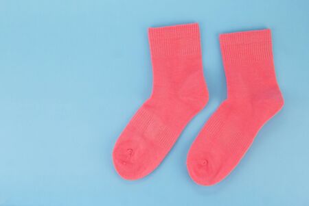 Pink socks on a blue background. Womens socks on a colored backgroundの写真素材