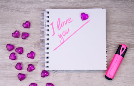 I love a pink letter, a Valentine card, a Notepad with the words I love you and a pen lying on a white background. Valentine day. Love letter. Marker writing.の写真素材