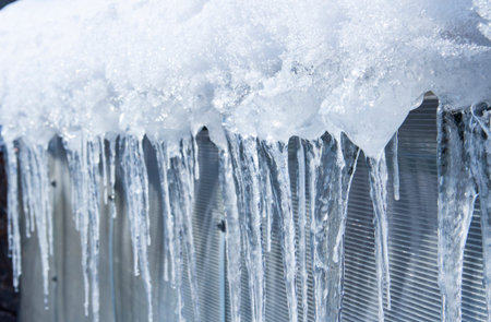 The icicles are melting. Spring thaw. Warm winter . Icicles close up. Close up of a large wavy...