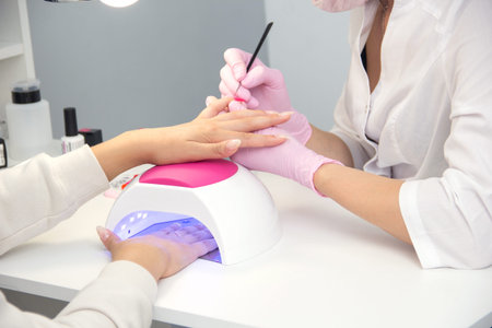 Closeup of Woman applying nail varnish to finger nails