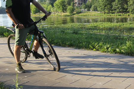 A man on a bicycle. Bicycle wheels close-up. The foot is on the bicycle pedal. Active summer