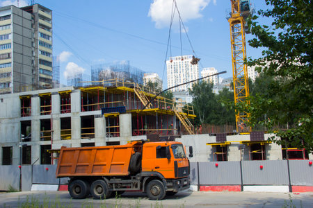 Mobile crane at construction site. The truck is parked next to a construction site. Construction of houses.の写真素材