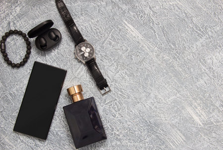 Men's watches, glasses, smartphone, accessories. Black accessories on a gray background.
