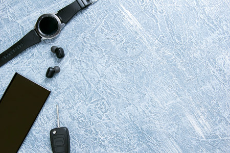 Men's watches, glasses, smartphone, accessories. Black accessories on a gray background.